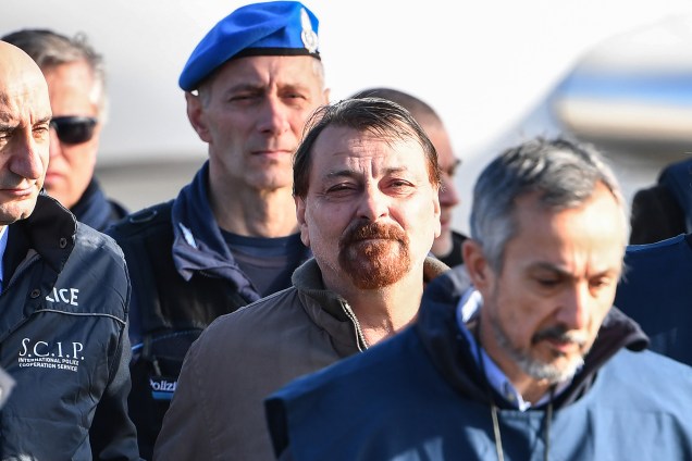 Cesare Battisti, procurado na Itália por envolvimento em quatro assassinatos atribuídos a um grupo de extrema-esquerda na década de 1970, é escoltado por policiais italianos ao desembarcar em Roma após ser preso na Bolívia - 14/01/2019