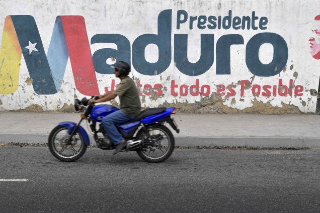 Motociclista passa em frente a um muro com o nome do presidente venezuelano Nicolás Maduro em Caracas, na Venezuela - 03/01/2019
