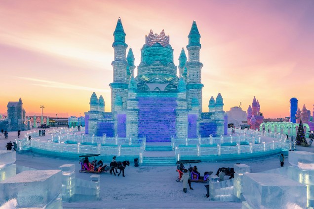 Pessoas visitam castelo esculpido em gelo no Festival Internacional de Esculturas de Gelo e Neve de Harbin, província de Heilongjiang, China - 04/01/2019