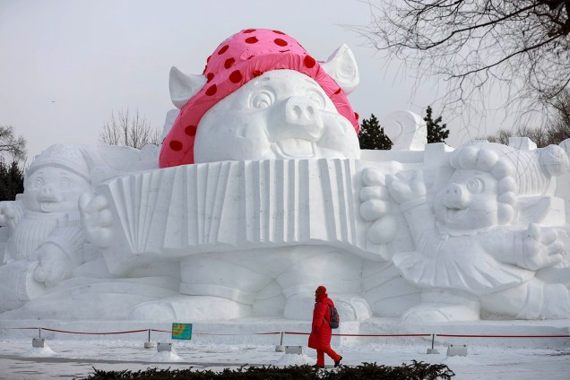 Visitante passa por escultura de porco feita de neve e gelo no Festival Internacional de Esculturas de Gelo e Neve de Harbin. A escultura representa o animal do próximo Ano Novo Lunar - 04/01/2019