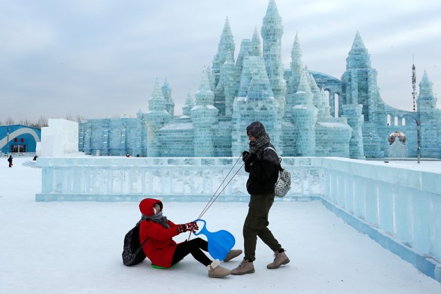 Visitantes brincam em frente a esculturas de gelo no Festival Internacional de Esculturas de Gelo e Neve de Harbin, província de Heilongjiang, China - 04/01/2019