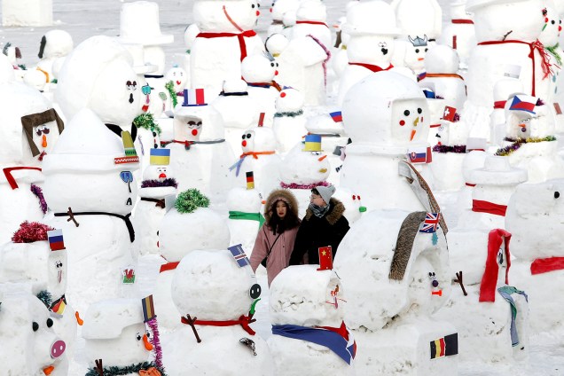 Casal caminha entre bonecos de neve que fazem parte de exibição no Festival Internacional de Esculturas de Gelo e Neve de Harbin, província de Heilongjiang, China - 04/01/2019