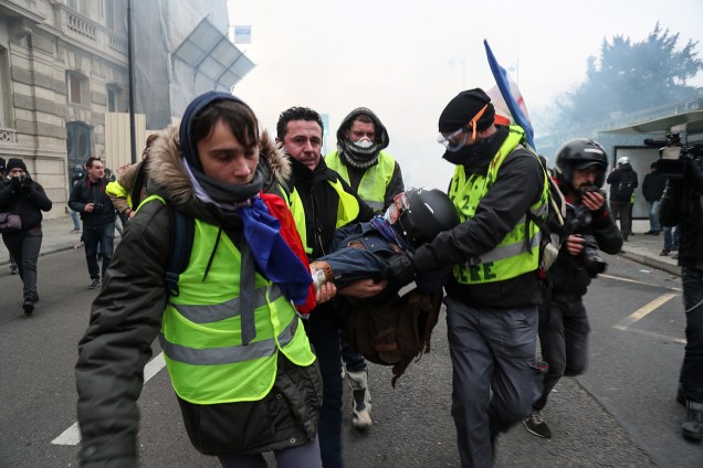 Maniestantes com coletes amarelos carregam fotógrafo ferido durante protestos contra o governo em Paris, capital da França - 05/01/2019