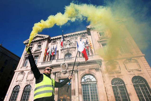 Manifestante com colete amarelo carrega bandeira francesa durante protestos contra o governo em Marselha - 05/01/2019