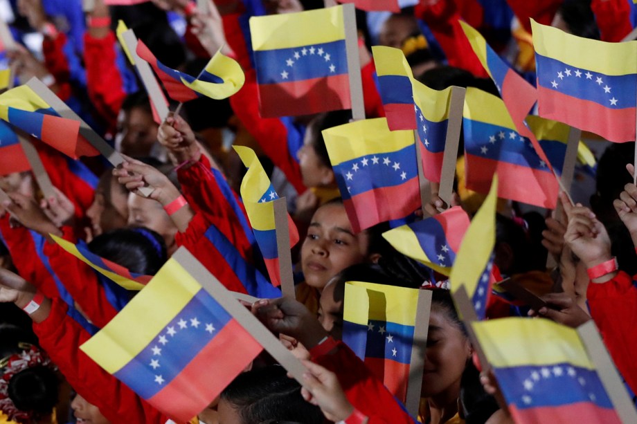 Crianças acenam com a bandeira da Venezuela durante a cerimônia de posse para o segundo mandato presidencial de Nicolás Maduro, na Suprema Corte de Caracas, Venezuela - 10/01/2019