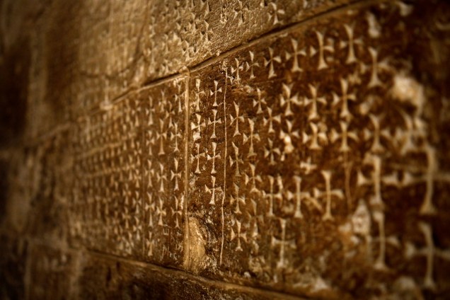 Cruzes esculpidas na parede por peregrinos são vistas ao lado de escadas que levam à Cripta de Santa Helena na Igreja do Santo Sepulcro na Cidade Velha de Jerusalém - 27/03/2018