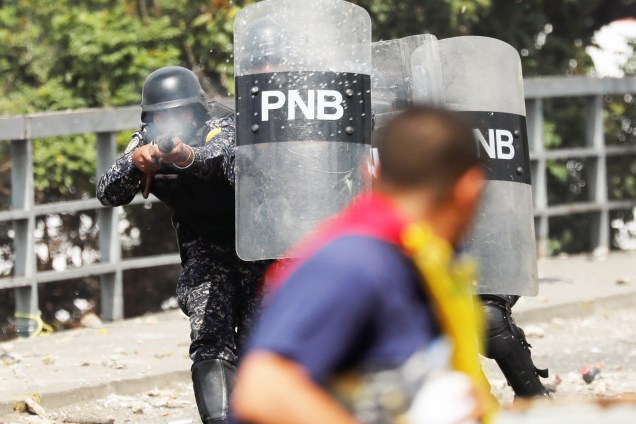 Policial atira contra manifestante durante marcha contra o governo do presidente venezuelano Nicolás Maduro, em Caracas - 23/01/2019