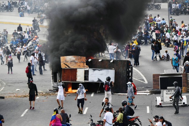 Veículo é incendiado durante marcha contra o governo do presidente venezuelano Nicolás Maduro, em Caracas - 23/01/2019