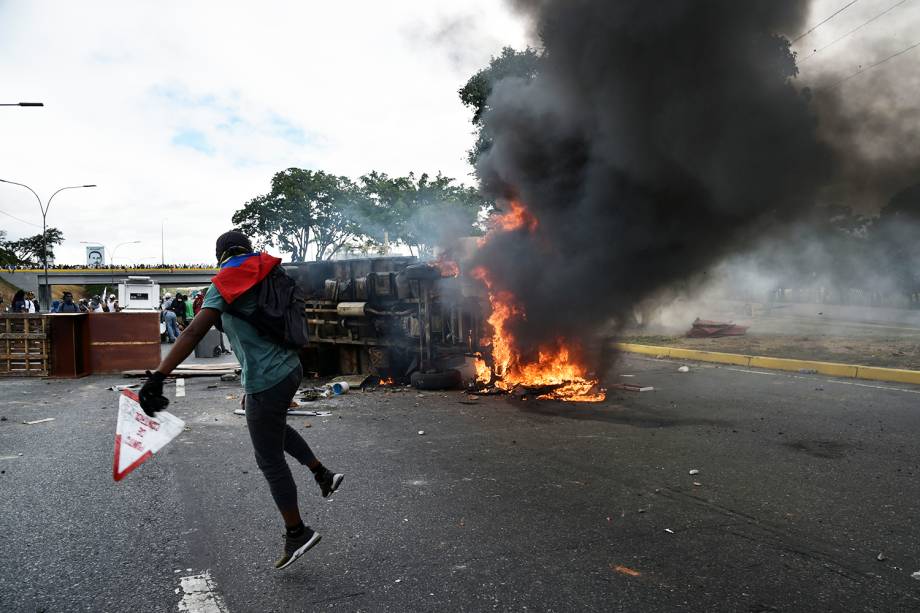 Veículo é incendiado durante marcha contra o governo do presidente venezuelano Nicolás Maduro, em Caracas - 23/01/2019