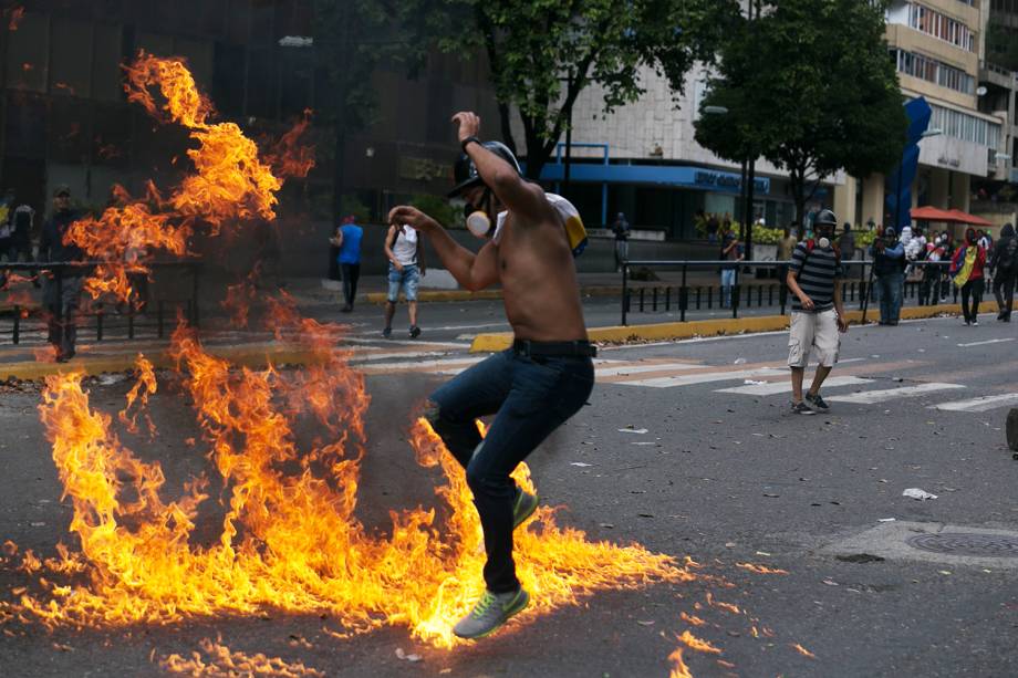 Manifestante salta sobre fogo durante protesto contra o governo do presidente venezuelano Nicolás Maduro, em Caracas - 23/01/2019