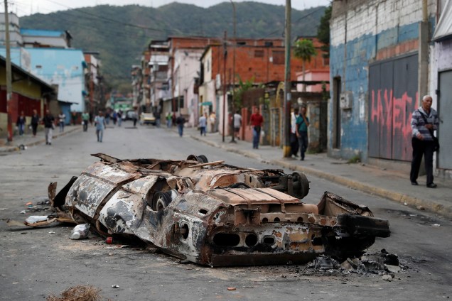 Um carro queimado durante os protestos contra o governo de Nicolas Maduro em Caracas, na Venezuela, é visto no meio da rua - 24/01/2019