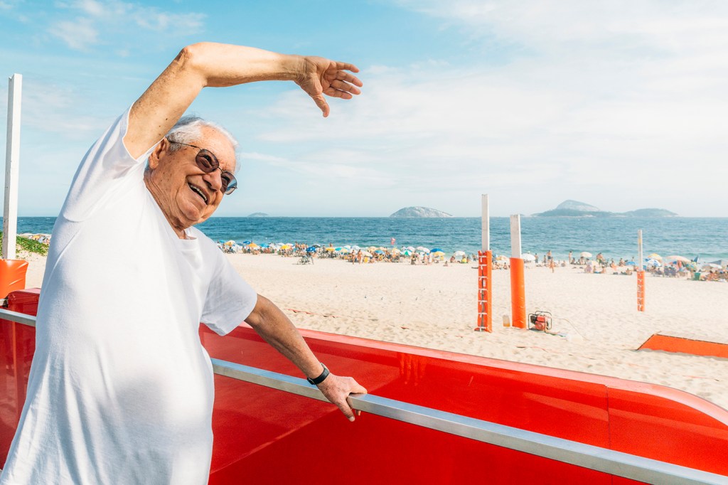 foto de idoso se alongando na praia