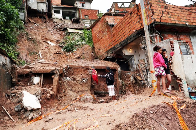 Moradores observam residências atingidas por deslizamento de terra em Mauá (SP), após forte chuva - 17/02/2019