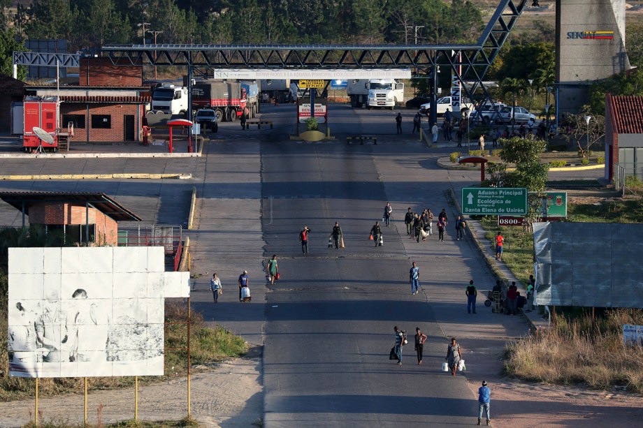 Pessoas carregam malas durante a travessia da Venezuela para o Brasil, em Pacaraima, no estado de Roraima - 22/02/2019