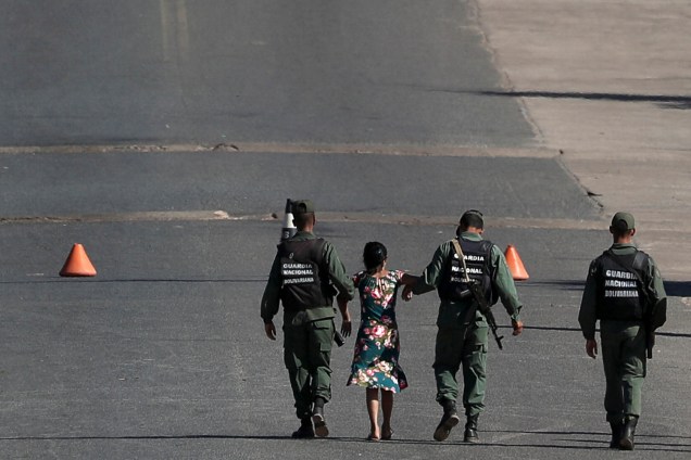 Mulher é carregada por militares venezuelanos na fronteira entre a Venezuela e o Brasil em Pacaraima, estado de Roraima - 22/02/2019