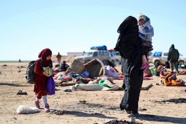Mulher e seus filhos que fugiram dos confrontos entre as Forças Democráticas Sírias e os jihadistas do Estado Islâmico aguardam para serem examinados e registrados pela SDF em Deir Ezzor, Síria - 03/02/2019