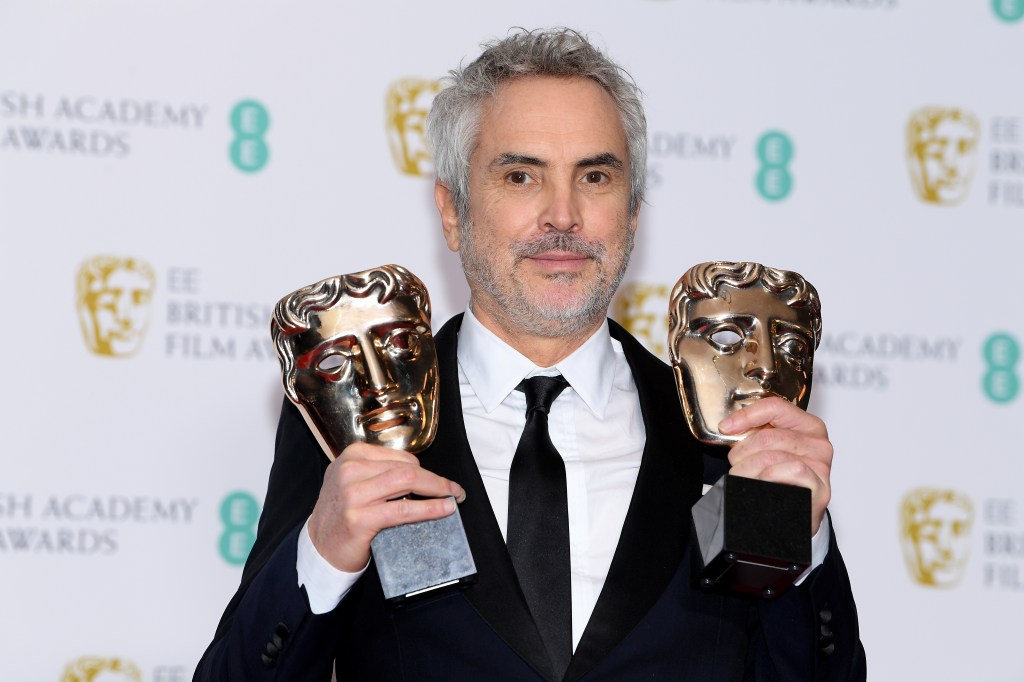 Diretor Alfonso Cuaron posa com os prêmios do Bafta de melhor diretor e melhor filme por 'Roma".