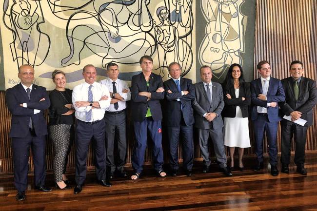 JAIR-BOLSONARO-PREVIDENCIA-2019 SEM ESTILO - Bolsonaro, cercado de ministros e auxiliares, com a camiseta pirata do Palmeiras e chinelos