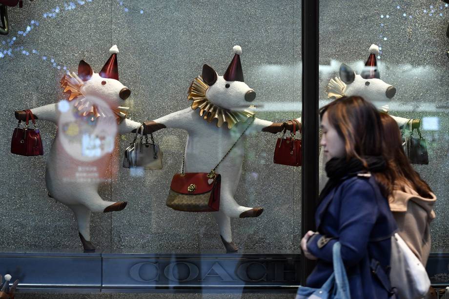 Mulher passa por vitrine decorada com porcos em comemoração do Ano Novo Lunar em Taipei, Taiwan - 23/01/2019
