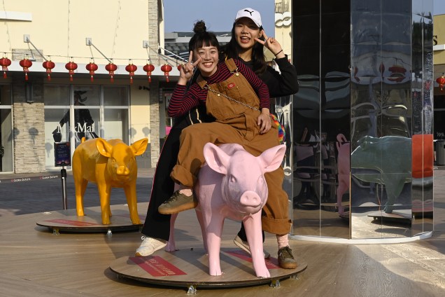 Mulheres posam para foto em escultura de porco em Taoyuan, Taiwan - 25/01/2019