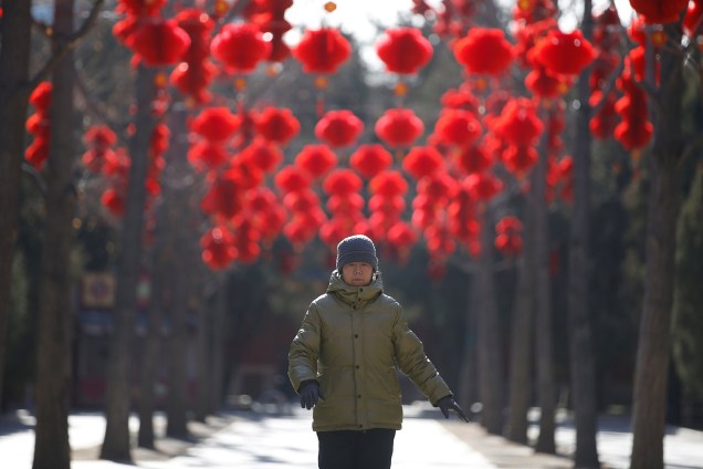 Mulher caminha entre as árvores decoradas com lanternas vermelhas em comemoração ao Ano Novo Lunar no Parque Ditan em Pequim, China - 28/01/2019