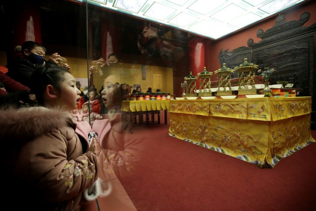 Menina observa exposição de objetos utilizados pela Dinastia Qing durante celebrações, as peças fazem parte de uma exibição em comemoração ao Ano Novo Lunar na Cidade Proibida em Pequim, China - 30/01/2019