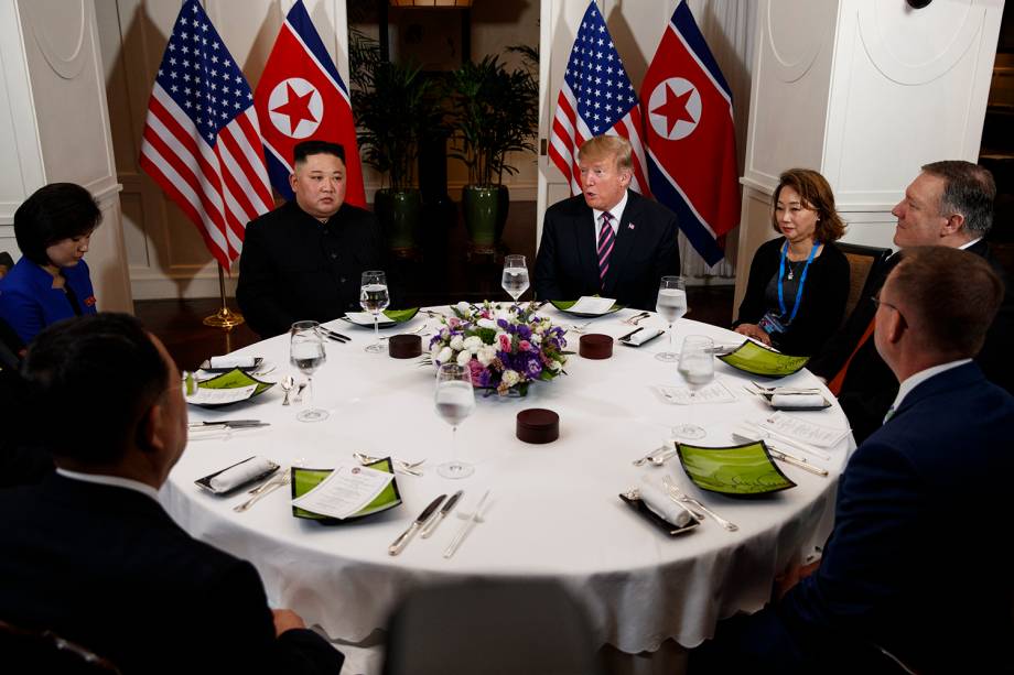 O líder norte-coreano Kim Jong-un e o presidente dos EUA Donald Trump conversam durante o jantar no Hotel Metropole, em Hanói, no Vietnã. À direita de Trump estão Mick Mulvaney, Chefe de Gabinete da Casa Branca, o Secretário de Estado Mike Pompeo e o intérprete. Do lado de Kim, o ministro norte-coreano dos Negócios Estrangeiros, Ri Yong Ho e o intérprete - 27/02/2019