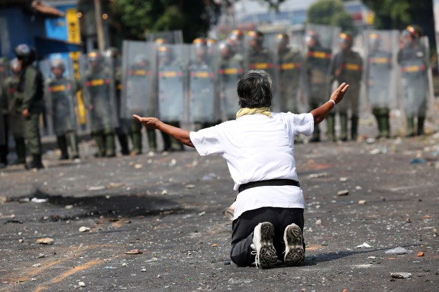 Manifestante ajoelha em frente a força de segurança em Ureña, Venezuela - 23/02/2019