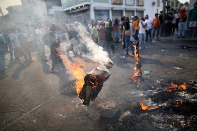 Manifestantes queimam uniforme da milícia durante confronto com as forças de segurança em Ureña, Venezuela - 23/02/2019
