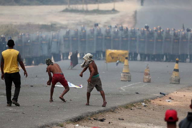 Pessoas atiram pedras contra a guarda nacional venezuelana na fronteira da Venezuela com o Brasil em Pacaraima, Roraima - 24/02/2019