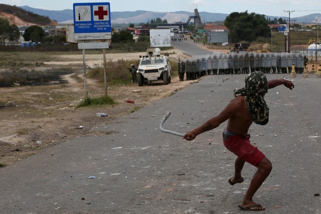 Homem lança objeto de metal em direção a guarda nacional venezuelana em Pacaraima, Roraima - 24/02/2019