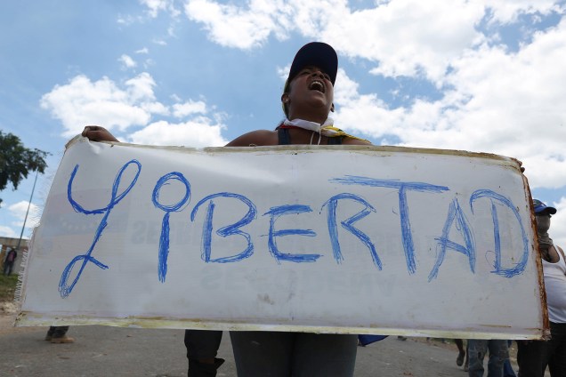 Manifestante exibe cartaz pedindo por liberdade na fronteira da Venezuela com a Colômbia em Pacaraima, Roraima - 24/02/2019