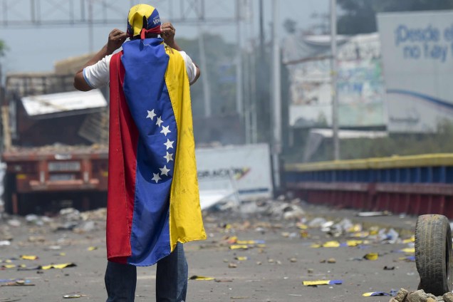 Manifestante veste a bandeira da Venezuela durante confronto na fronteira da Venezuela com a Colômbia em Ureña, Venezuela - 24/02/2019