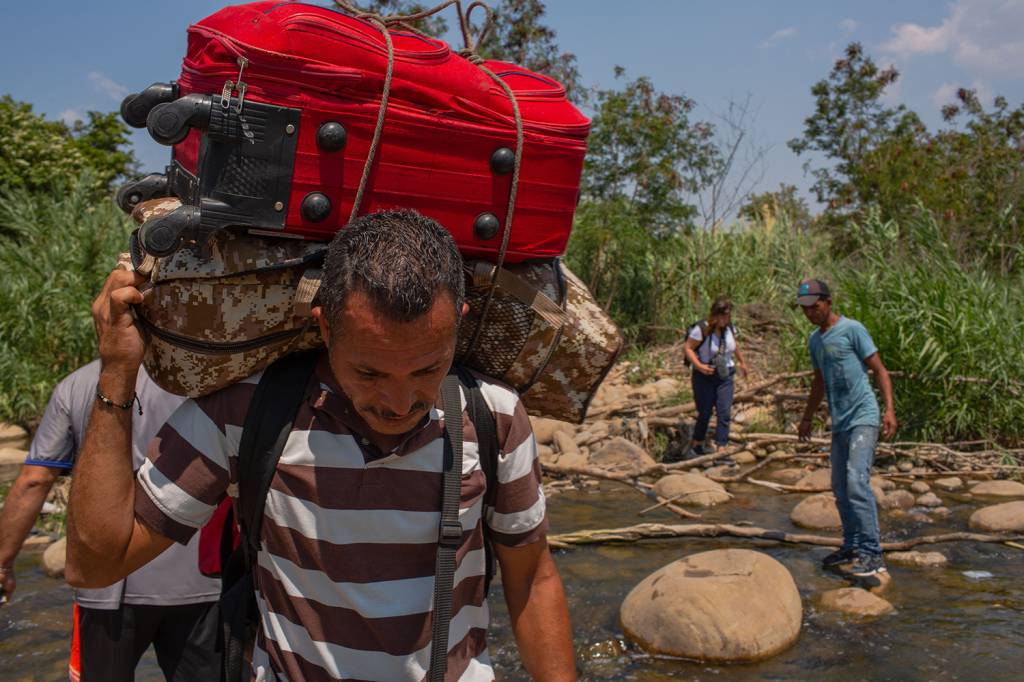 Venezuelanos cruzam o Rio Táchira, na trilha ilegal na fronteira com a Colômbia, para buscar o que for possível carregar de volta para seu país – 28/02/2019