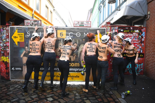 Membros do movimento feminista Femen derrubam o portão de acesso à Herbertstrasse, uma rua no distrito da luz vermelha pavimentada com bordéis e reservada apenas a homens, durante o Dia da Internacional Mulher, em Hamburgo, norte da Alemanha - 08/03/2019