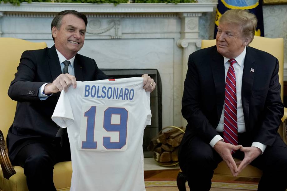 Donald Trump presenteia Jair Bolsonaro com uma camisa da seleção americana de futebol, durante encontro na Casa Branca, em Washington - 19/03/2019 Donald Trump presenteia Jair Bolsonaro com uma camisa da seleção americana de futebol, durante encontro na Casa Branca, em Washington - 19/03/2019