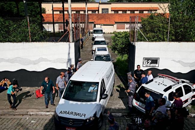 Carros funerários retiram corpos da E.E Raul Brasil Carros funerários retiram corpos da E.E Raul Brasil
