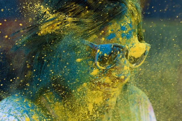 Uma participante tem pó colorido jogado contra seus óculos durante a celebração do Festival Holi em Mumbai, na Índia - 21/03/2019