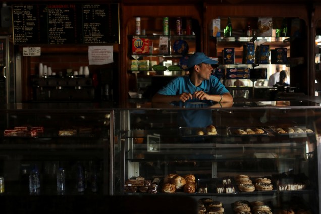 Trabalhador fica dentro de uma padaria às escuras durante  apagão em curso em Caracas, Venezuela - 10/03/2019