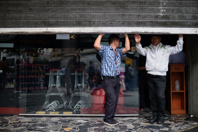 Empregados fecham as portas de um supermercado, durante um corte de energia em Caracas, na Venezuela - 07/03/2019