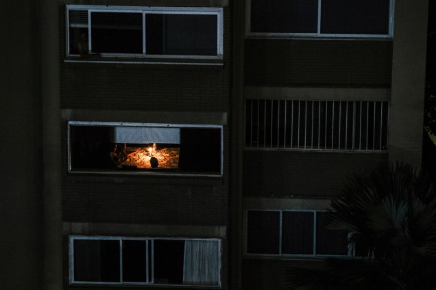 Moradores usam velas para iluminar um apartamento durante o terceiro dia do apagão que afeta Caracas e grande parte da Venezuela - 10/03/2019