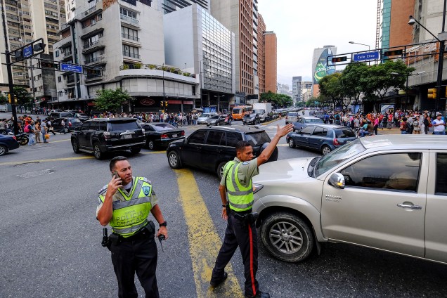 Policiais direcionam o tráfego em uma interseção durante um corte de energia em Caracas, na Venezuela - 07/03/2019