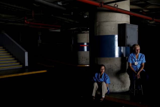 Trabalhadores esperam o retorno da energia elétrica em uma garagem durante um apagão em Caracas, na Venezuela - 25/03/2019 Trabalhadores esperam o retorno da energia elétrica em uma garagem durante um apagão em Caracas, na Venezuela - 25/03/2019