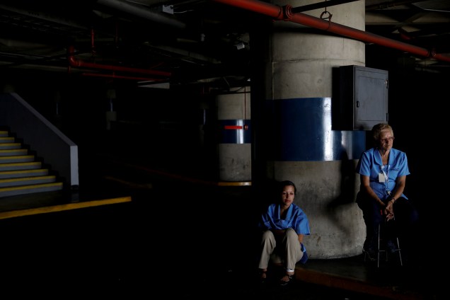 Trabalhadores esperam o retorno da energia elétrica em uma garagem durante um apagão em Caracas, na Venezuela - 25/03/2019