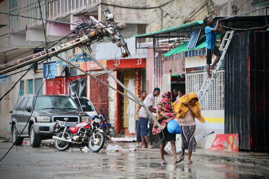 Moradores se protegem da chuva após a passagem do ciclone Idai na Beira, em Moçambique - 17/03/2019