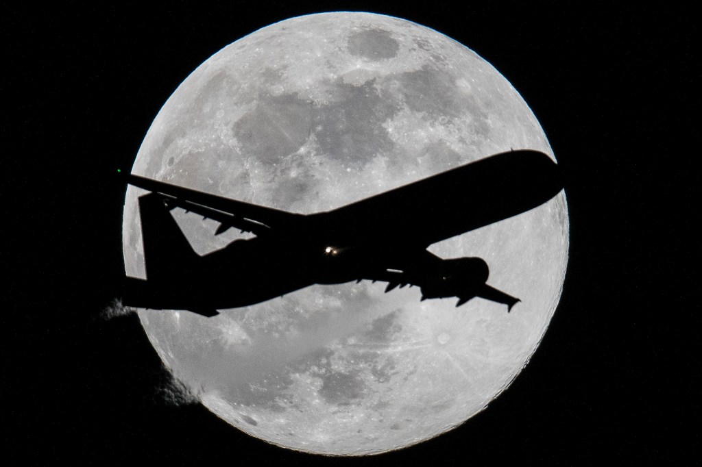 Avião é fotografado com a lua cheia ao fundo