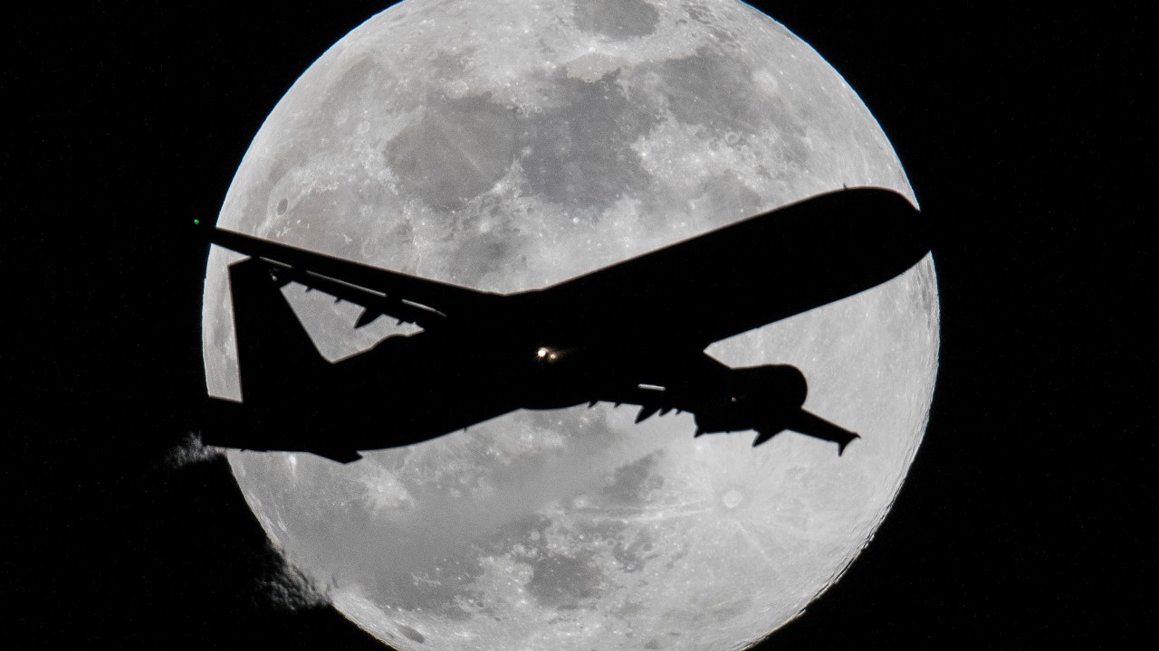 Avião é fotografado com a lua cheia ao fundo