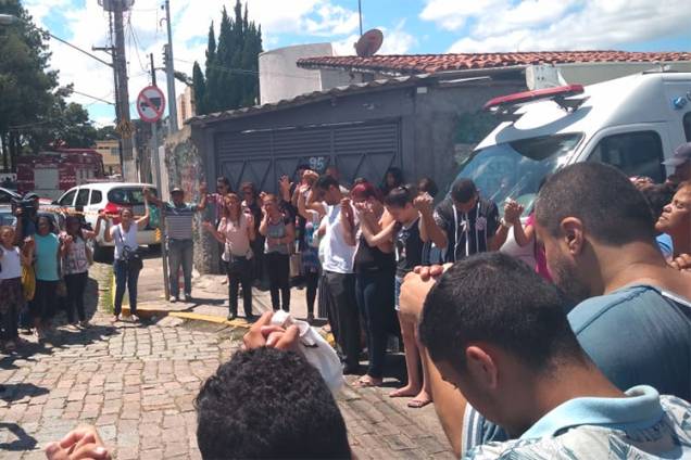 Familiares, alunos e vizinhos fazem oração em frente à Escola Estadual Raul Brasil, horas depois do ataque