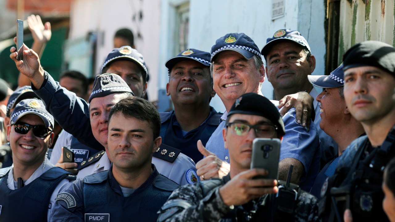 Presidente, Jair Bolsonaro,posa para foto com policiais depois de visita privada a uma criança na favela da Estrutural, em Brasília - 27/04/2019