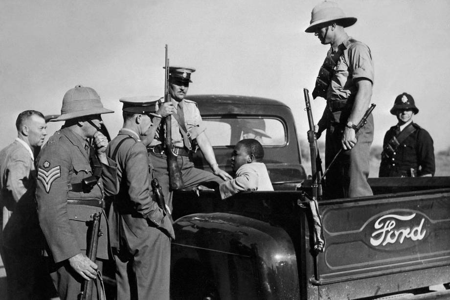 Homem negro é detido por policiais na cidade de East London, localizada na África do Sul - 01/10/1952